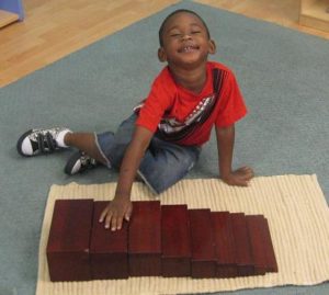 Montessori student with size blocks